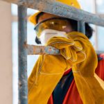 Construction worker inspecting scaffolding for safety and stability on a construction site.