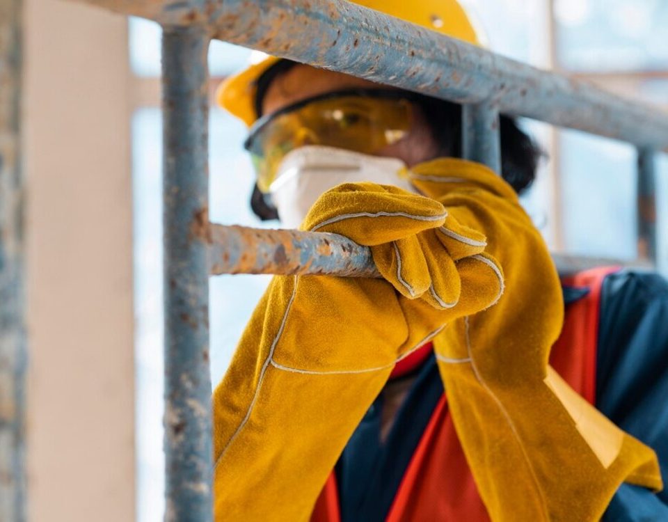 Construction worker inspecting scaffolding for safety and stability on a construction site.