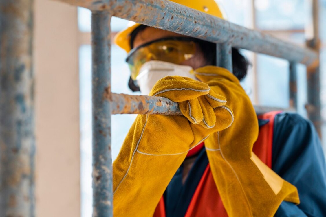 Construction worker inspecting scaffolding for safety and stability on a construction site.